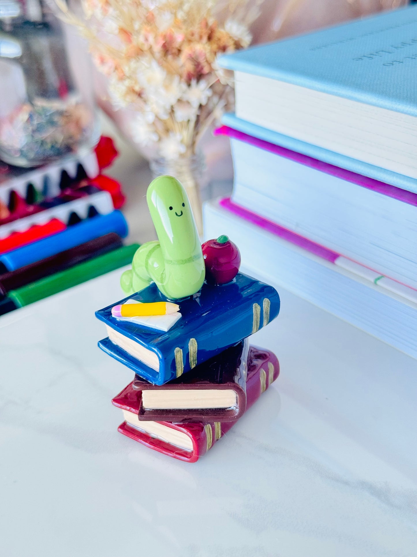 Wrigley the Worm desk friend handmade polymer clay figurine with books, apple, pen, and paper for desk décor