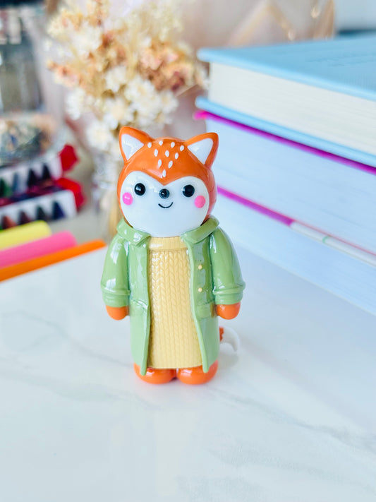 Toy figure of a fox in a green coat 