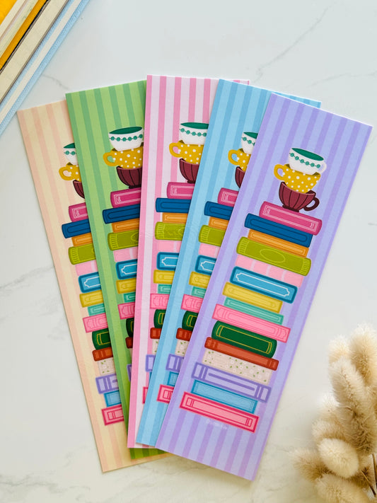 Hand-illustrated bookmark with stacks of books and coffee cups