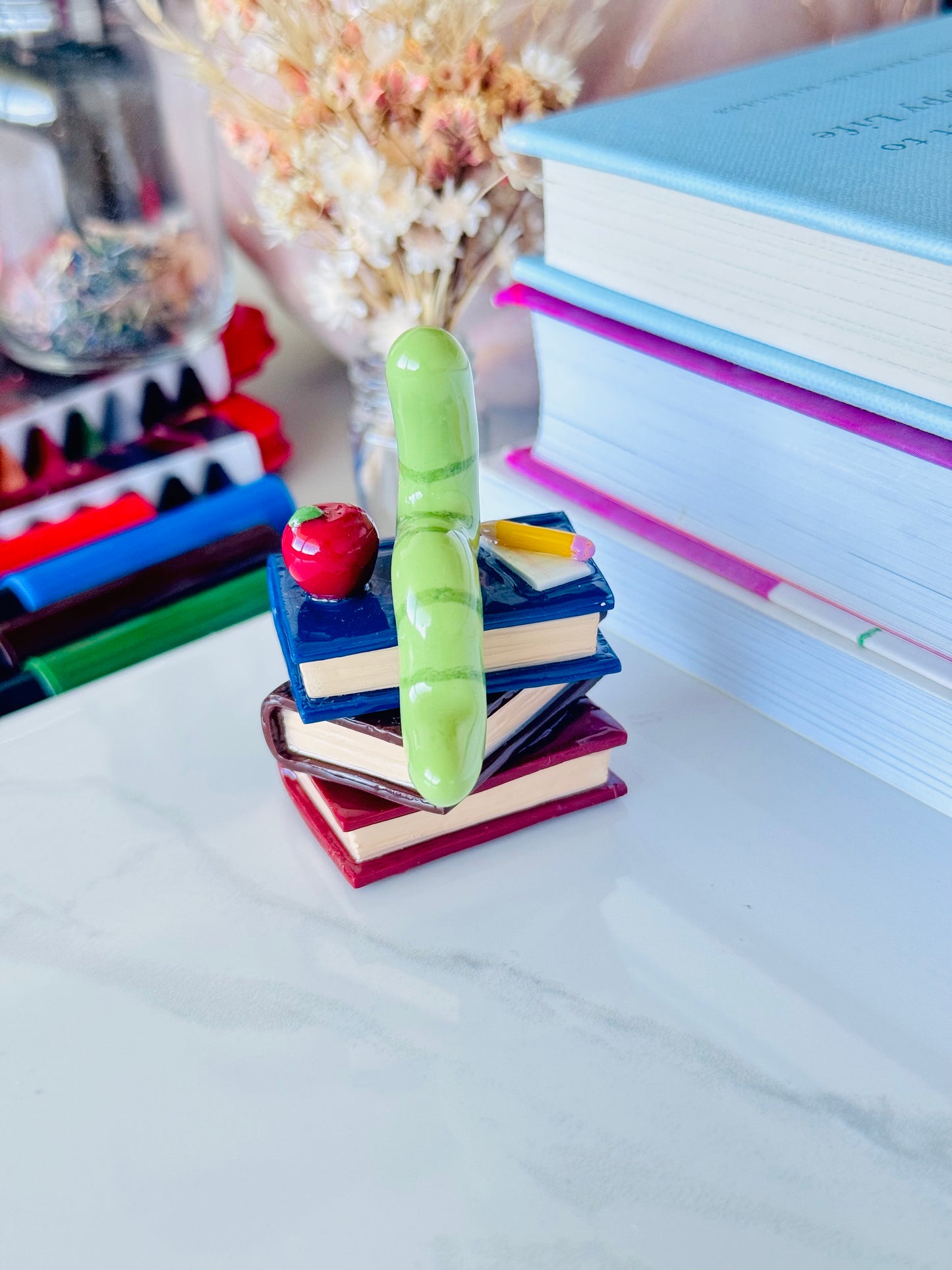 Wrigley the Worm desk friend handmade polymer clay figurine with books, apple, pen, and paper for desk décor