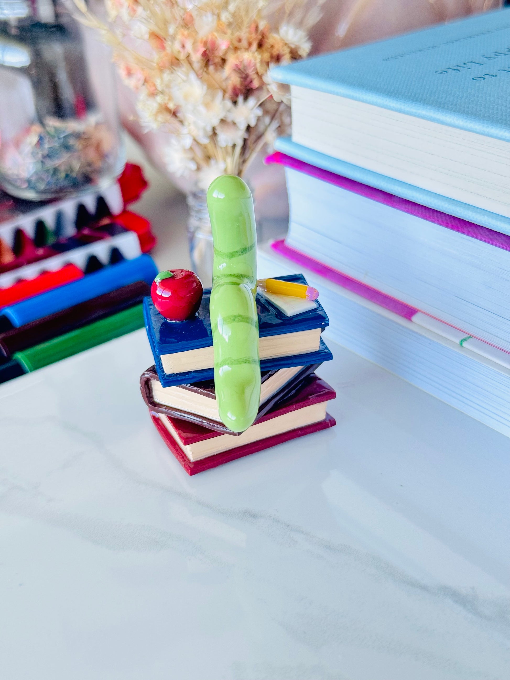 Wrigley the Worm desk friend handmade polymer clay figurine with books, apple, pen, and paper for desk décor