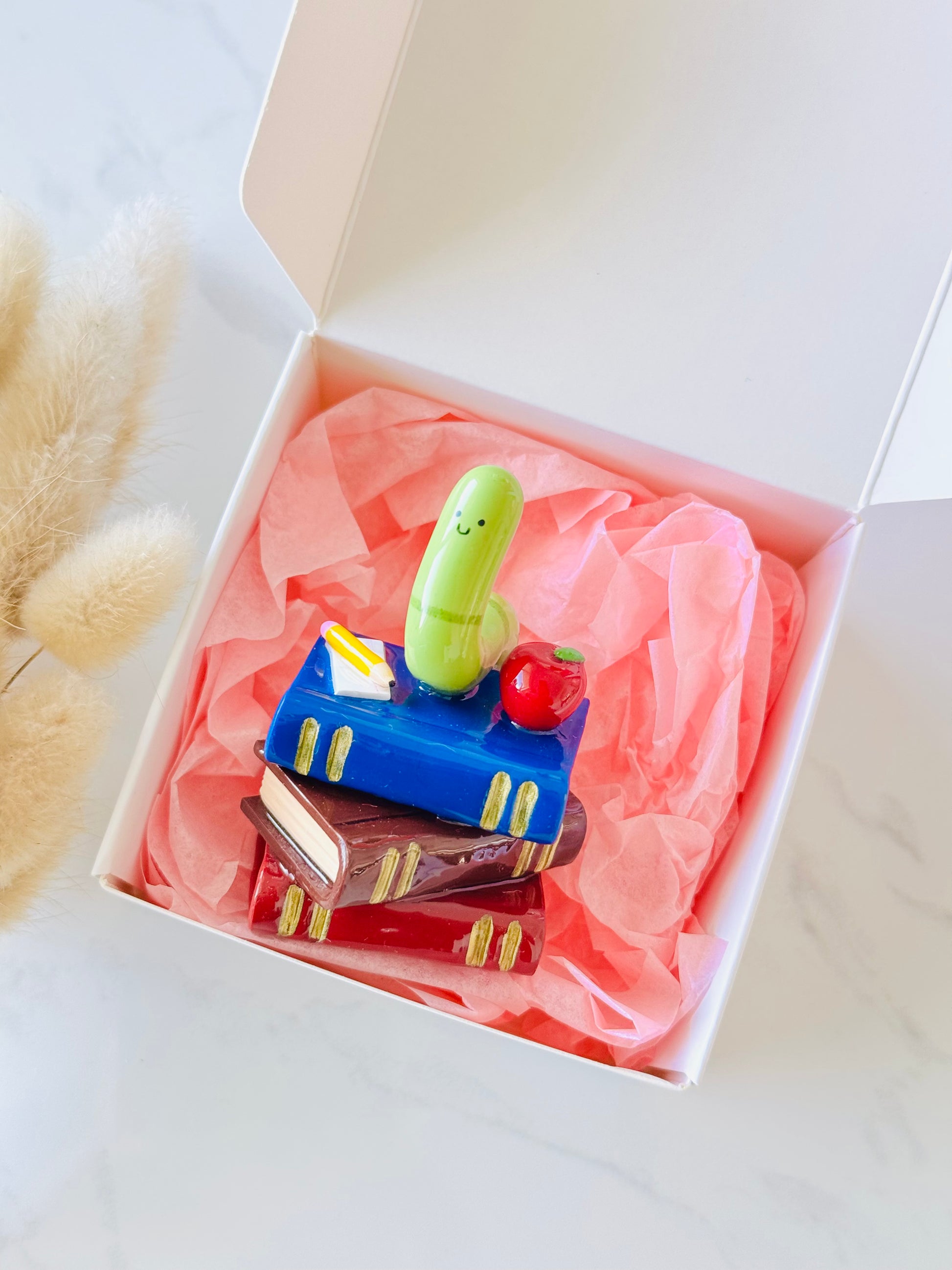 Wrigley the Worm desk friend handmade polymer clay figurine with books, apple, pen, and paper for desk décor